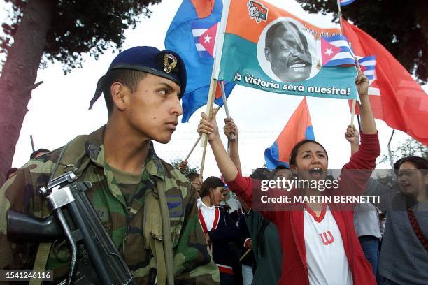 Women holding a flag of murdered Ecuatorian communist representative, Jaime Hurtado, yells slogans while waiting with other supporters for the...