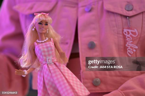 Woman holds a Barbie doll after watching the "Barbie" film at the SM North Edsa in Quezon City on July 19, 2023.