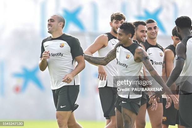 Barcelona's Spanish midfielder Oriol Romeu is welcomed by teammates during a training session at the Joan Gamper training ground in Sant Joan Despi,...