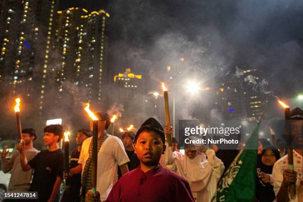 Muslim hold torches and sing an Islamic song as they parade to welcome the Islamic New Year in Jakarta on 18 July 2023. Hundreds of Indonesian...