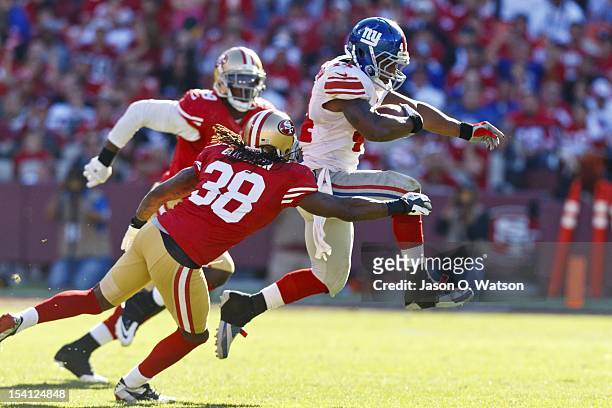 Running back Ahmad Bradshaw of the New York Giants breaks a tackle from free safety Dashon Goldson of the San Francisco 49ers during the fourth...