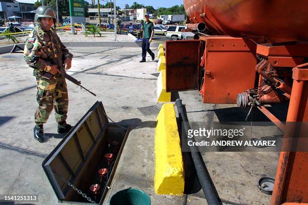 Venezuelan soldier patrols a truck that distributes gasoline in Maracaibo, 22 December 2002, after three weeks of general strike by the opposition...