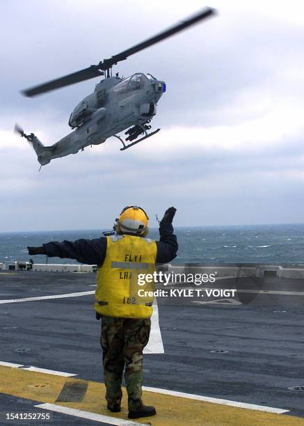 Avaiation Boatswains Mate 3rd Class Jennifer Rohrbaugh from Pittsburgh, PA, signals an AH-1W "Super Cobra" helicopter, assigned to Marine Air Group...