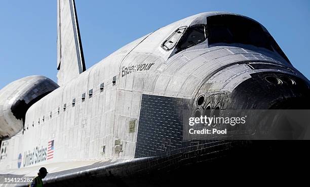 Workman helps in the process of prepping the Space Shuttle Endeavour to move the final few yards into a temporary hangar at the California Science...