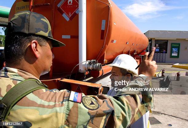 Venezuelan Army soldier stands guard as a fuel truck enters a gas station in the city of Maracaibo, 500 km west of Caracas 21 December 2002. In...