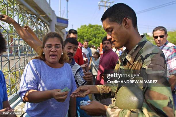 National guard soldier directs people waiting in line to get gasoline 16 December 2002 in Maracaibo, Venezuela. Oil prices streaked up to two-month...