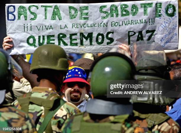 Soldiers secure the area during demonstrations in Caracas, Venezuela 05 December 2002. Un manifestante a favor del presidente Hugo Chavez muestra una...