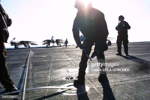 Sailor tightens a bolt on the flight deck of the USS Constellation 23 December 2002 in the Gulf. The USS Constellation is conducting operations to...