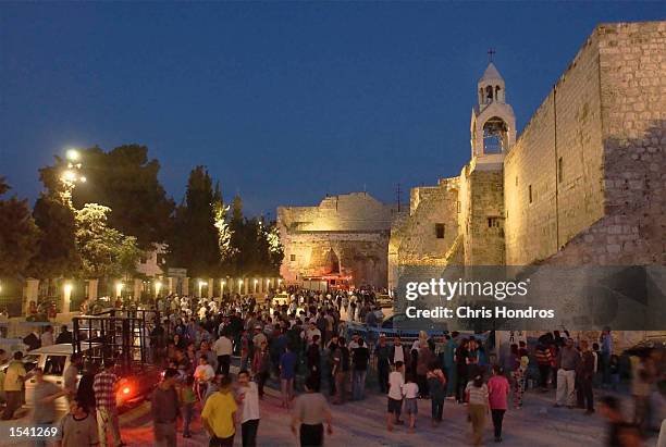 People mill about near the Church of the Nativity after a standoff at the church ended May 10, 2002 in the West Bank City of Bethlehem. The 38-day...