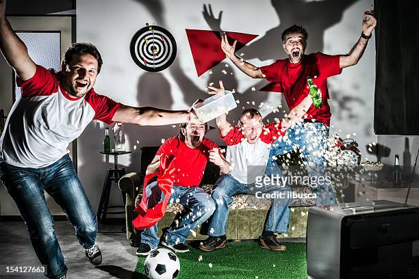 quatre jeune adulte homme amis regarder le football à la télévision: but ! - friendly match photos et images de collection