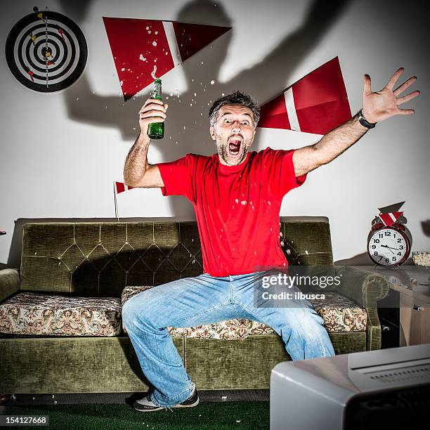 young adult man watching football on television: goal! - american football fans stock pictures, royalty-free photos & images