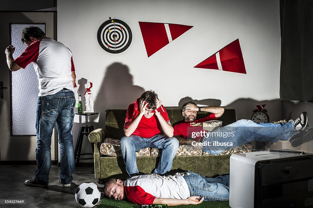 4 人の若い友人を眺められる成人男性のサッカーのテレビで。敗北