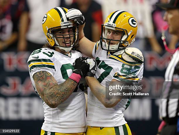 Jordy Nelson of the Green Bay Packers celebrates with teammate Tom Crabtree after Nelson's third touchdown in the third quarter against the Houston...