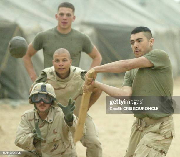 Lance Corporal Julio Roman, 19 of Santa Ana, CA, bats during an informal baseball game among service men of the 1st Platoon, Golf Company of the 2nd...