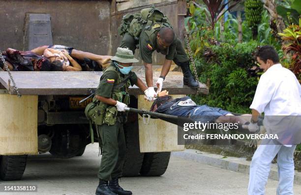 Colombian soldiers load a truck with two civilian corpses that were murderd during a massacre last thursday in a rural zone of the municipality of...