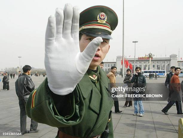 Chinese paramilitary policeman gestures while patrolling Tiananmen Square, 04 March 2003. Final preparations for China's 2,900-member National...