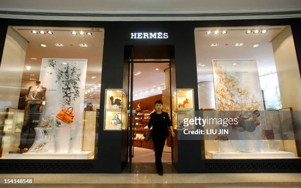 Shop staff walks out of an outlet of the French fashion brand Hermes in Shanghai, 19 June 2007. The luxury icon opened a new store to mark its 10th...