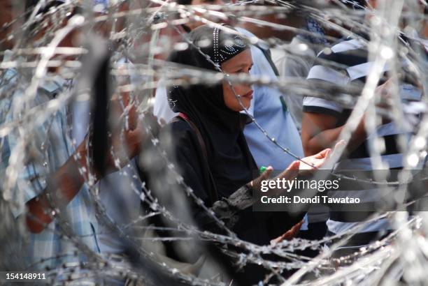 Filipino Muslims practice noon prayers at a peace rally near the presidential palace as a peace pact is signed between the Philippine government and...