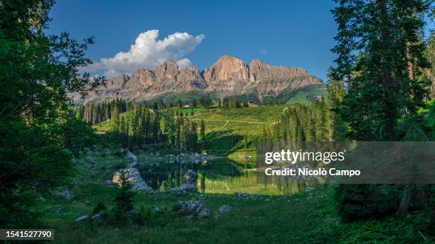 View showing Rosengarten mountain mirroring in the lake Karersee .