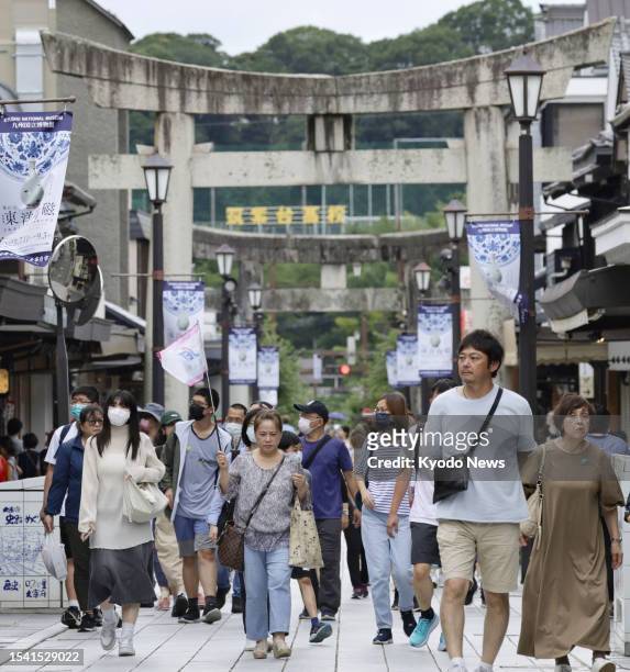 Foreign tourists walk on the approach to Dazaifu Tenmangu temple in southwestern Japan city of Fukuoka on July 19, 2023. Government data shows...