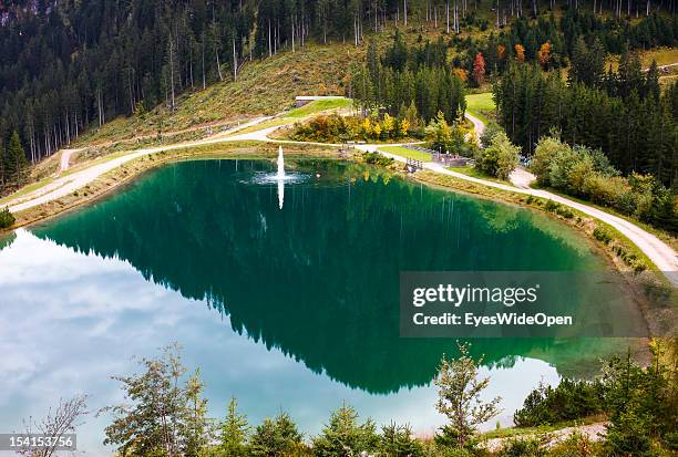 The green mountain lake Seidlalm See at Hahnenkamm slope which is used for the production of artificial snow in the tyrolean alps on October 05, 2012...