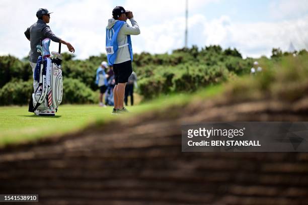 Golfer Rickie Fowler stands with his caddie on the 5th fairway during a practice round for 151st British Open Golf Championship at Royal Liverpool...