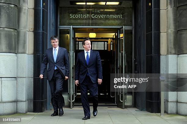 British Prime Minister David Cameron and Scottish Secretary Michael Moore leave St Andrews House in Edinburgh on October 15, 2012 after the signing...