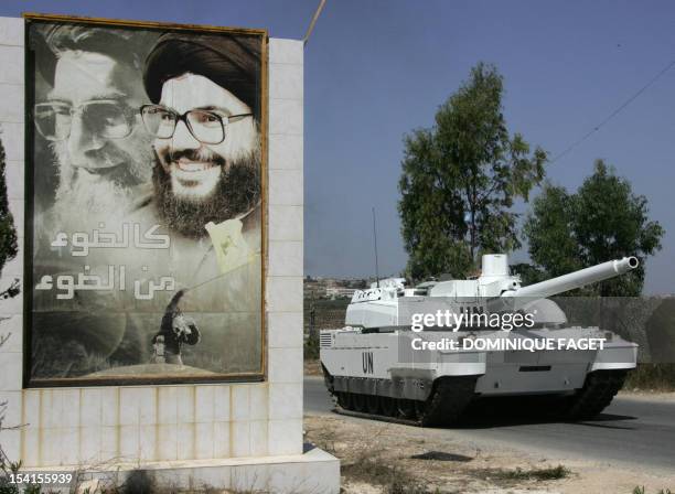 French UNIFIL Leclerc tank drives past of portraits of Iranian supreme leader Ayatollah Ali Khamenei and Hezbollah leader Hassan Nasrallah at the...