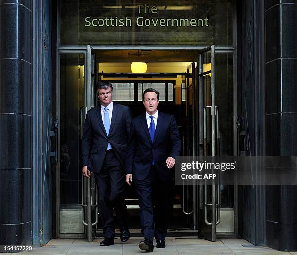 British Prime Minister David Cameron and Scottish Secretary Michael Moore leave St Andrews House in Edinburgh on October 15, 2012 after the signing...