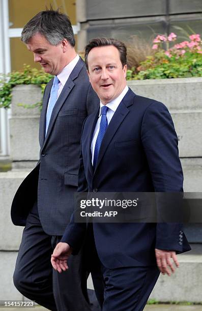 British Prime Minister David Cameron and Scottish Secretary Michael Moore leave St Andrews House in Edinburgh on October 15, 2012 after the signing...