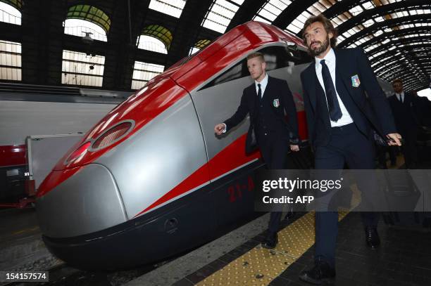 Italian players Andrea Pirlo and Ignazio Abate disembark from a train at Milan Central Station on October 15, 2012 on the eve of their team's World...