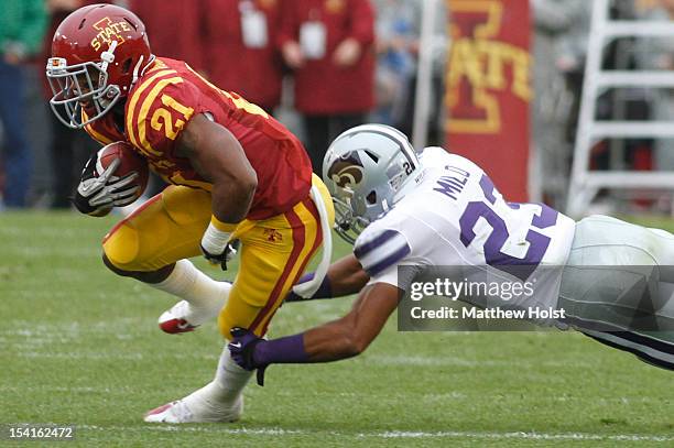 Running back Shontrelle Johnson of the Iowa State Cyclones rushes up field during the first quarter past defensive back Jarard Milo of the Kansas...