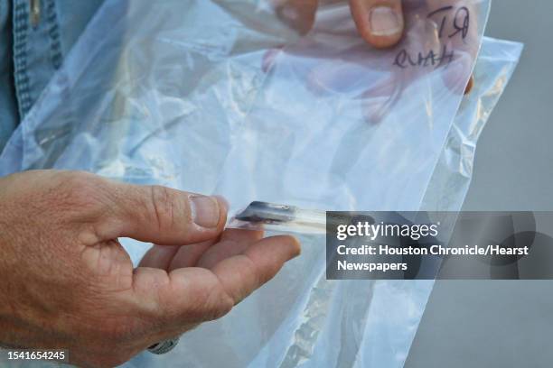 Houston Police officer holds a crack pipe seized during a drug bust, Wednesday, April 27 in Houston.