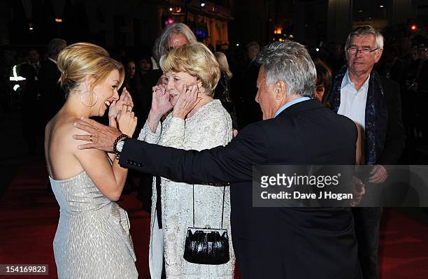 Actress Dame Maggie Smith puts her fingers in her ears as actress Sheridan Smith and director Dustin Hoffman look on at the premiere of 'Quartet'...