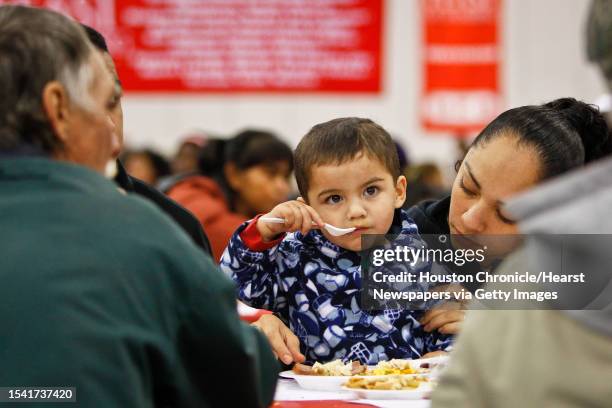 Lio Calvillo takes a bite to eat with the help of his mother Marisol Gonzalez during the 2011 H-E-B 6th Annual Feast of Sharing dinner at the George...