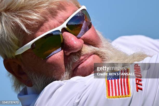 Flag and the words 'Trump' are pictured on the sleeve of US golfer John Daly as he plays a shot from the 10th tee during a practice round for 151st...
