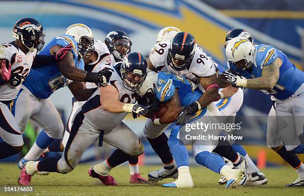 Kevin Vickerson and Justin Bannan of the Denver Broncos tackle runningback Ryan Mathews of the San Diego Chargers during the NFL game at Qualcomm...