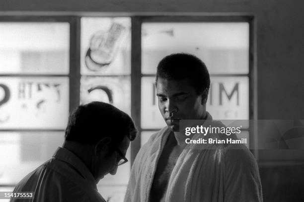 American boxing coach Angelo Dundee tapes the hand of heavyweight boxer Muhammad Ali during training at the 5th Street Gym, Miami, Florida, 1971. Ali...