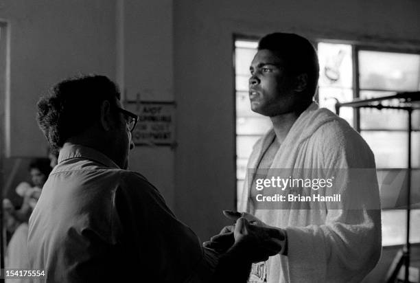 American boxing coach Angelo Dundee tapes the hand of heavyweight boxer Muhammad Ali during training at the 5th Street Gym, Miami, Florida, 1971. Ali...