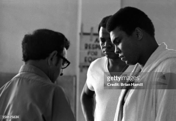 American boxing coach Angelo Dundee tapes the hand of heavyweight boxer Muhammad Ali during training at the 5th Street Gym, Miami, Florida, 1971. Ali...
