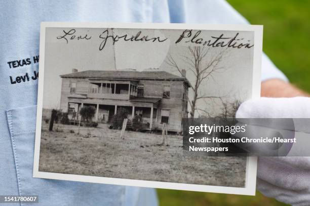 Bryan McAuley, Site Manager, holds a early photograph of the two-story Greek Revival-style plantation house at the Levi Jordan Plantation State...