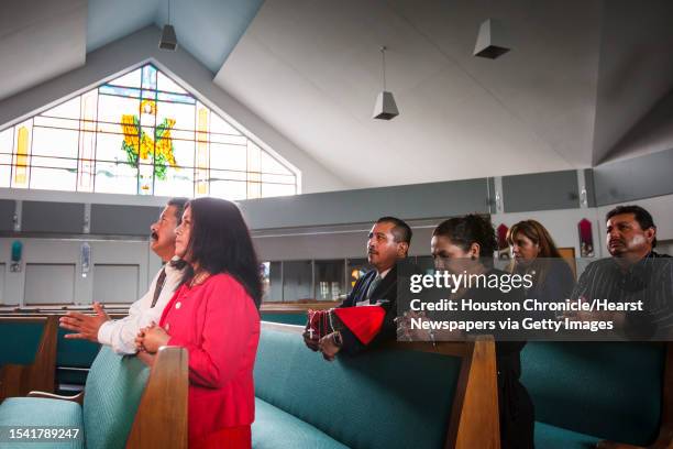 Martin Medina and his wife Rosario, and Pedro Salas and his wife Pilar, and Maty Montoya and her husband Jose pray at St. Jerome Catholic Community...