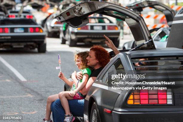 Gigi Larrabee gets her picture taken with Quin Woolley as they sit in a DeLorean during the 53rd Annual St. Patrick's Parade through downtown...