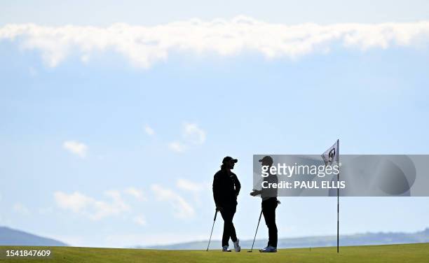 England's Tommy Fleetwood talks with Northern Ireland's Rory McIlroy on the 17th green during a practice round for 151st British Open Golf...