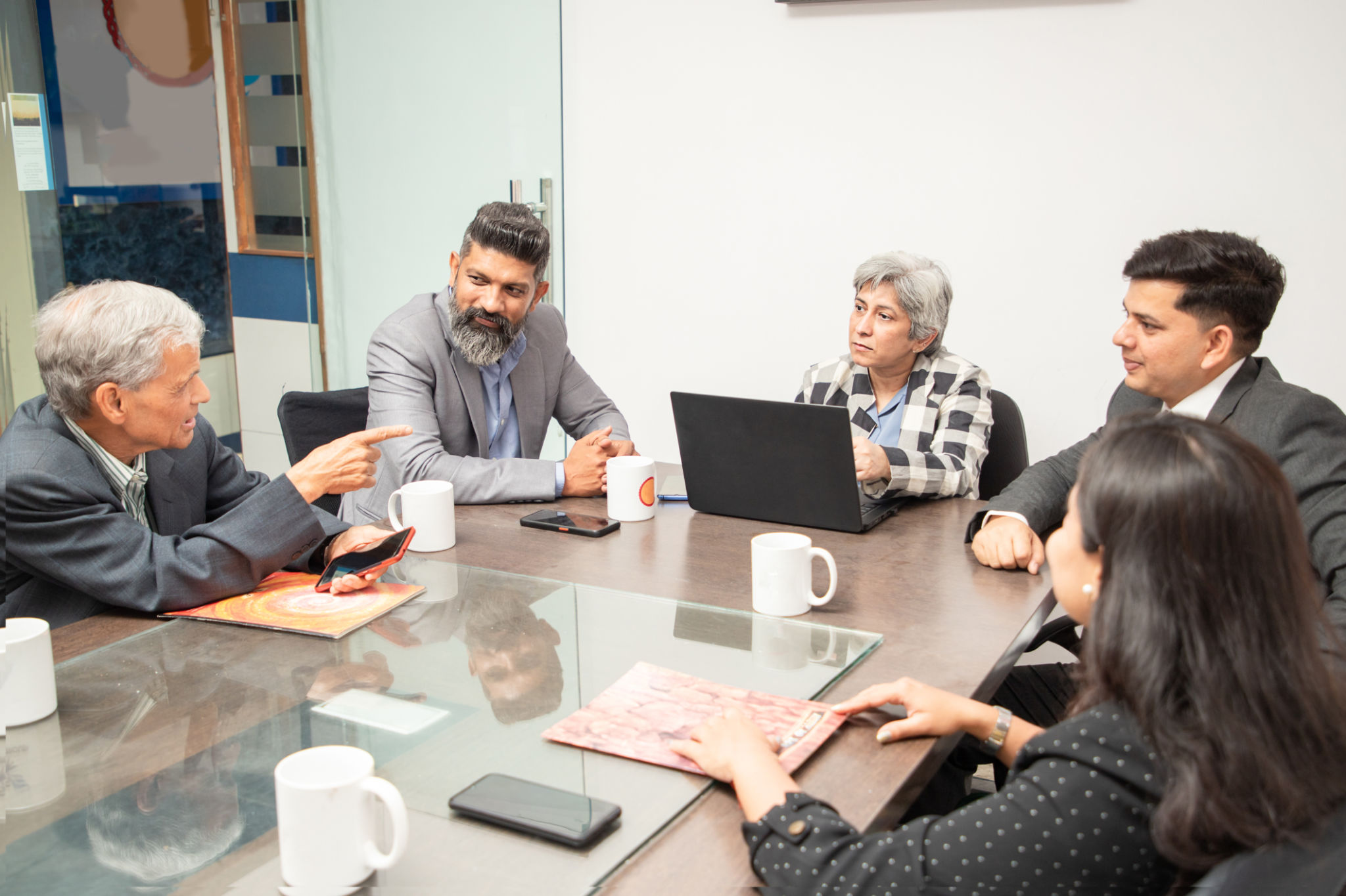 Group of Indian business people having a meeting at conference or board room discussing over new project in office. Group of Indian business people having a meeting at conference or board room discussing over new project in office.