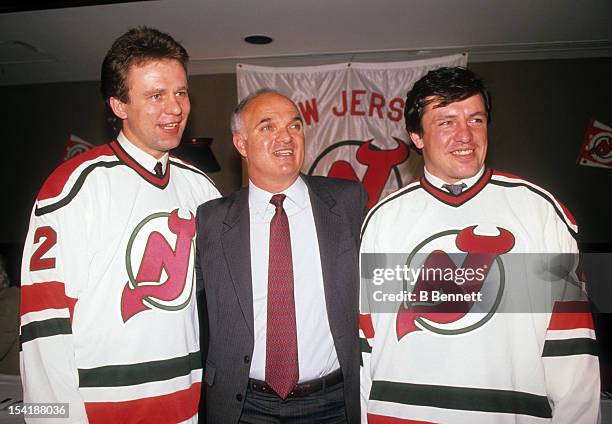 Lou Lamoriello of the New Jersey Devils stands with Viacheslav Fetisov and Sergei Starikov of the Soviet Union after they signed with the Devils...