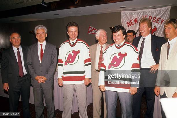 Lou Lamoriello and other members of the New Jersey Devils stand with Viacheslav Fetisov and Sergei Starikov of the Soviet Union after they signed...