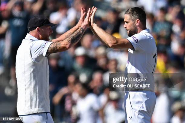 England's Chris Woakes celebrates with England's captain Ben Stokes after taking the wicket of Australia's Cameron Green on the opening day of the...