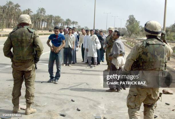 Soldiers order Iraqis to pull down their pants, as they fear suicide bombers on Baghdad's al-Durra highway 10 April, 2003. As the regime of Saddam...