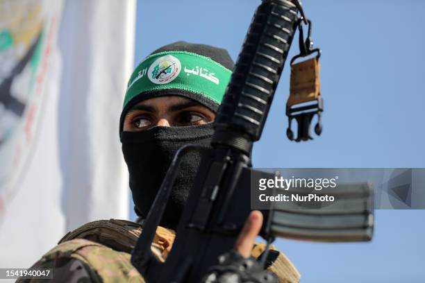 Palestinian fighters from the armed wing of Hamas are taking part in a military parade in front of an Israeli military site to mark the anniversary...